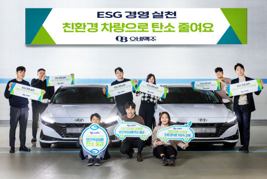 29일 오비맥주 영업부문 직원들이 영업차량을 친환경 하이브리드 차량으로 교체하고 기념촬영을 하고 있다. <오비맥주 제공>